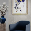 Mise en scène dans un petit coin salon, au dessus d'un fauteuil en tissu bleu foncé, le tableau "Luna" de la série picutrale "Ad Astra".