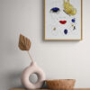 Mise en scène du tableau Adage d'Or de la série picturale Arabesque. Le tableau contemporainest est accroché au dessus d'une étagère sur laquelle reposent des décorations modernes.