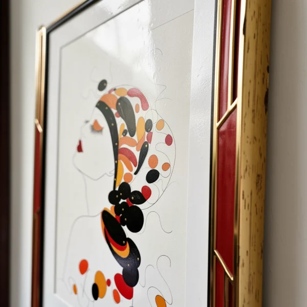 Illustration de style Art déco d'une femme de profil aux ornements colorés, dans un cadre rouge et doré