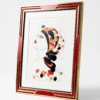 Illustration Art déco d'un tableau moderne de l'artiste internationale confirmée Alessandra Viotti-Gilabert, dont le motif représente une femme de profil dans un cadre géométrique rouge et or.